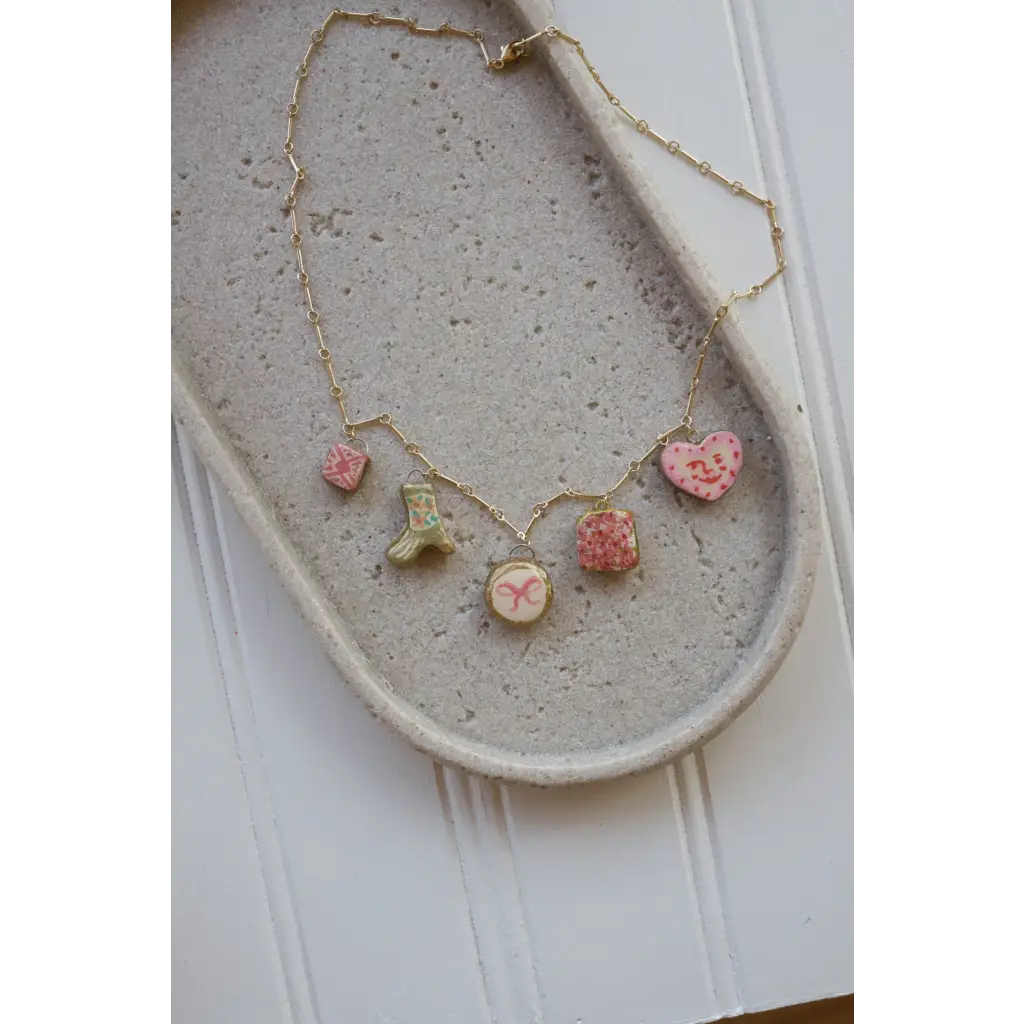 Gold chain necklace with five pastel-colored clay seaside charms for a pretty seaside charm look