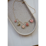 Gold chain necklace with five pastel-colored clay seaside charms for a pretty seaside charm look