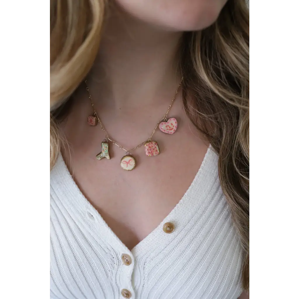 Gold-toned seaside charm necklace with colorful clay charms and pink heart details