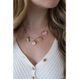 Gold-toned seaside charm necklace with colorful clay charms and pink heart details