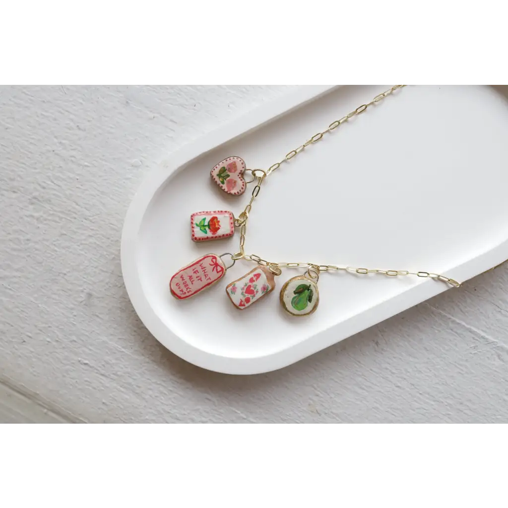 Gold chain necklace with five embroidered clay seaside charms from No 7 Its Working Out