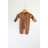 Brown organic cotton baby zipper romper hanging on wooden hanger for comfy cuteness