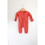 Coral Organic Cotton Baby Zipper Sleeper hanging on wooden hanger for cozy comfort