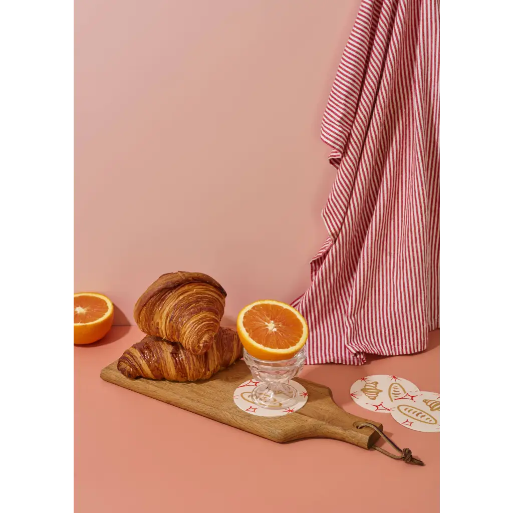 Golden-brown croissants on wooden board with Oui Croissants Coasters polished prints