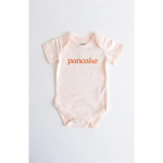 Light pink pancake organic cotton onesie for cozy cuties with fun orange text