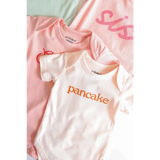 Cute pink and white baby onesies made of organic cotton for cozy cuties