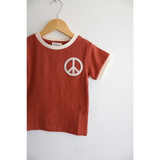 Rust Peace Embroidered Ringer Tee for Kids hanging on a wooden hanger, perfect everyday ringer