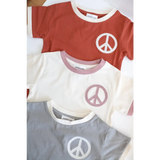 Three peace embroidered ringer tees in rust red, white, and gray for kids