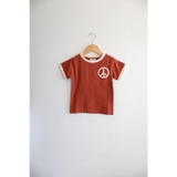 Rust Peace Embroidered Ringer Tee for Kids hanging on a hanger, perfect everyday ringer