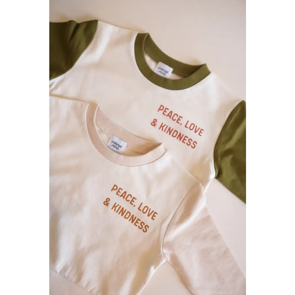 Cream t-shirts with olive sleeves showcasing Peace Love & Kindness in organic cotton