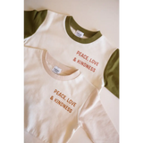 Cream t-shirts with olive sleeves showcasing Peace Love & Kindness in organic cotton