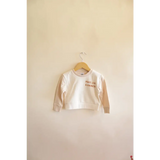 White long-sleeved children’s organic cotton Peace Love Kindness Pullover on hanger
