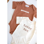 Two cute baby onesies in brown and cream saying Peanut and Tater Tot, made from organic cotton