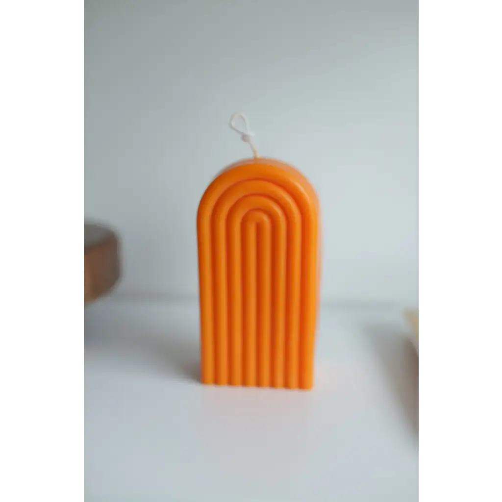 Orange arch-shaped candle with grooves for a fun Petite Rainbow Candle vibe