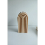 Cream-colored arch sculpture with curved lines around a Petite Rainbow Candle display