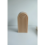 Cream-colored arch sculpture with curved lines around a Petite Rainbow Candle display