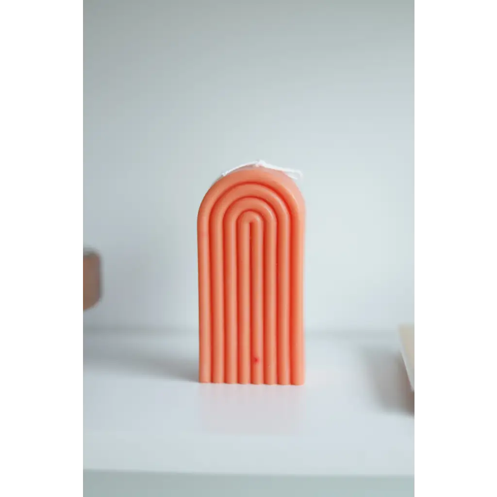 Peach-colored arch-shaped Petite Rainbow Candle with grooved lines for a fun home vibe