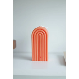 Peach-colored arch-shaped Petite Rainbow Candle with grooved lines for a fun home vibe