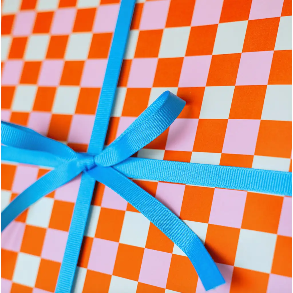 Blue ribbon bow on Bright Pitaya Wrapping Paper with vibrant checkered design