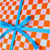 Blue ribbon bow on Bright Pitaya Wrapping Paper with vibrant checkered design