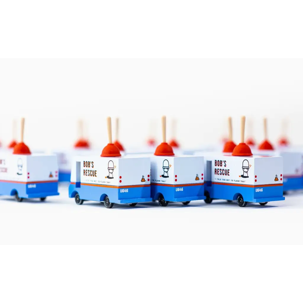 Line of blue and white toy food trucks on Bob’s Plumbing Van in solid beech wood