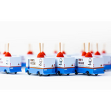 Line of blue and white toy food trucks on Bob’s Plumbing Van in solid beech wood