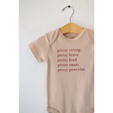 Tan baby onesie with empowering text made from pretty brave organic cotton