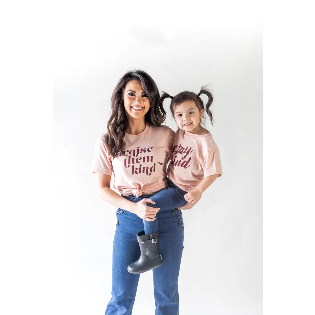 Parent and child in matching pink organic cotton graphic t-shirts against a plain backdrop