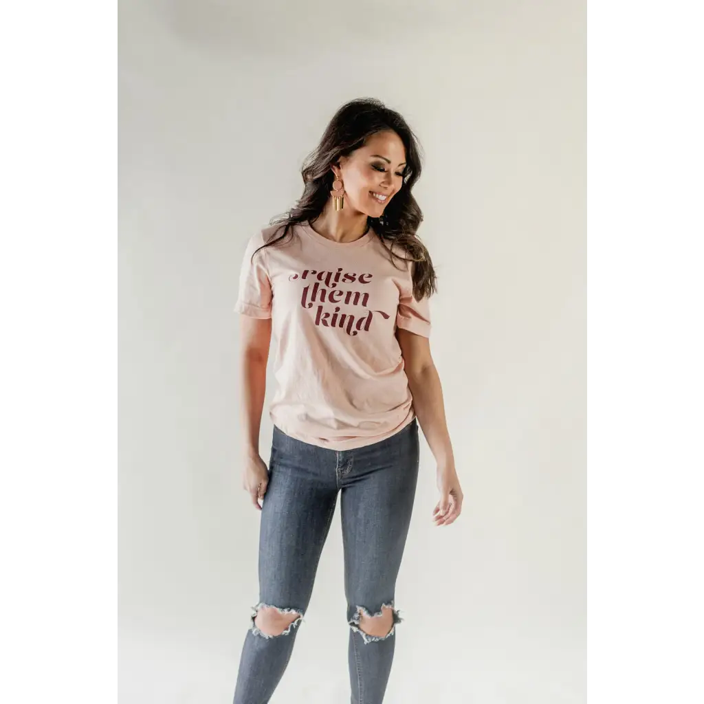 Pink Raise them Kind graphic t-shirt in organic cotton paired with distressed blue jeans