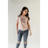 Pink Raise them Kind graphic t-shirt in organic cotton paired with distressed blue jeans