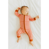Sleeping baby in a red gingham bamboo baby sleeper with a zipper