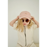 Pink baseball cap with rainbow emblem worn with adorable round sunglasses for kids