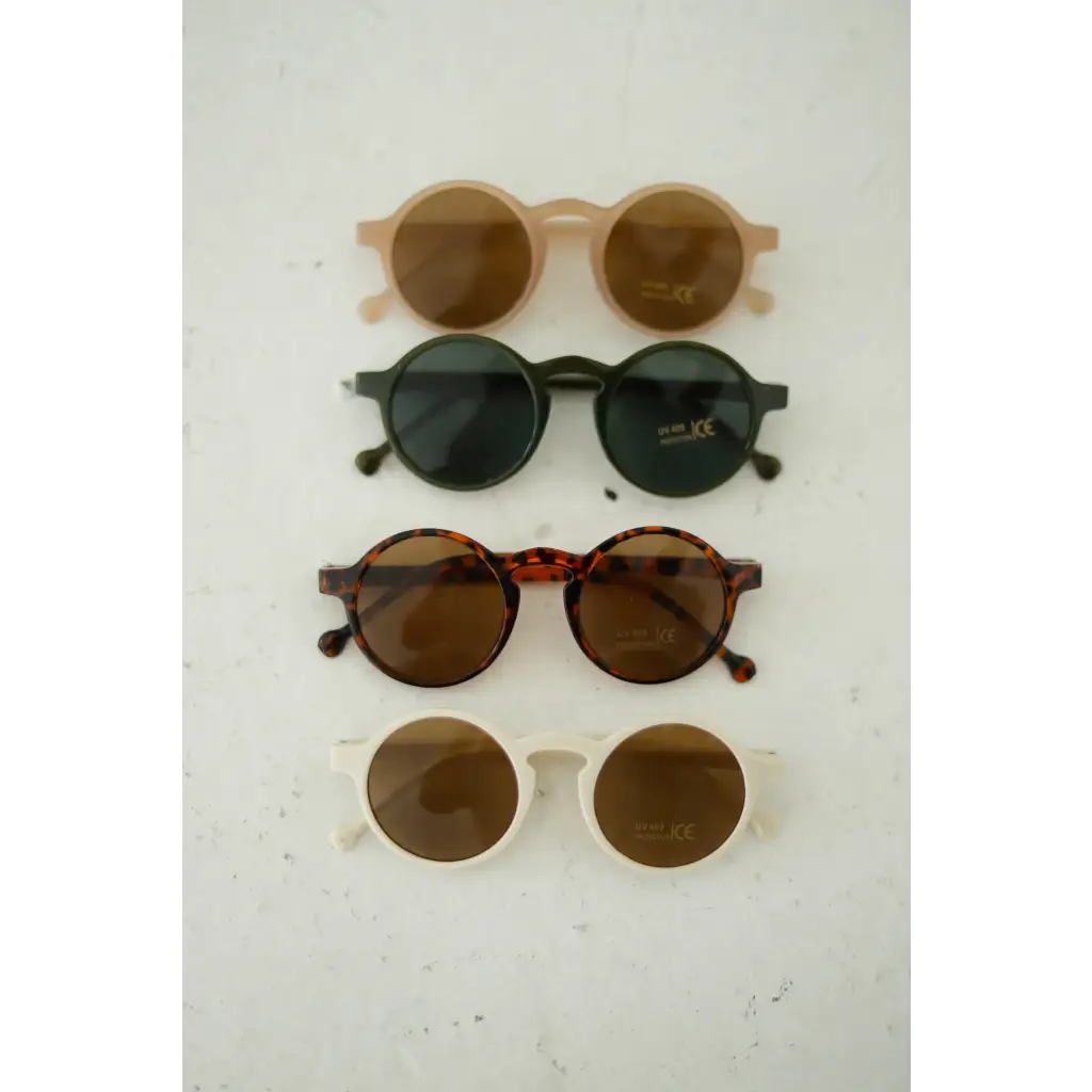 Four pairs of adorable round sunglasses in stylish brown and black tones for kids