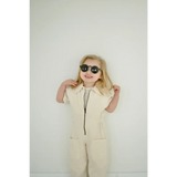 Person in cream jumpsuit and dark sunglasses showcasing Adorable Round Sunglasses