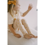 Child in white top and yellow polka dot leggings from Shine Bright Star collection