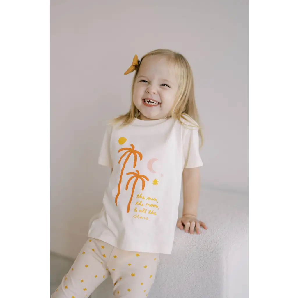 Joyful toddler in Shine Bright Star Flexible Lightweight Leggings with palm trees and polka dots
