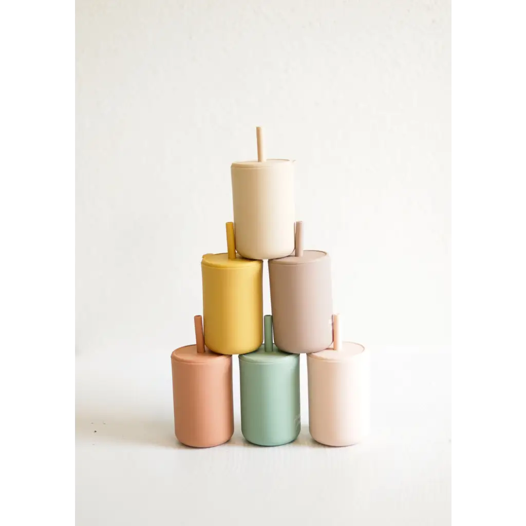 Six pastel cylindrical candles stacked in a pyramid by Pastel Mini Silicone Straw Cups for Kids