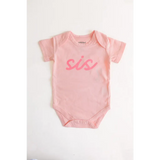 Pink sis organic cotton onesie for baby sister making her debut in cute style