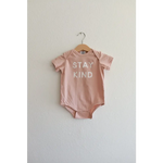 Cute pink baby onesie in organic cotton fabric features Stay Kind slogan for little ones