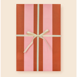 Cute pink and red striped gift box with cream bow showcasing modern wrapping paper