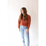 Rust-colored Annie Cardigan Sweater styled with light wash jeans for a chic look