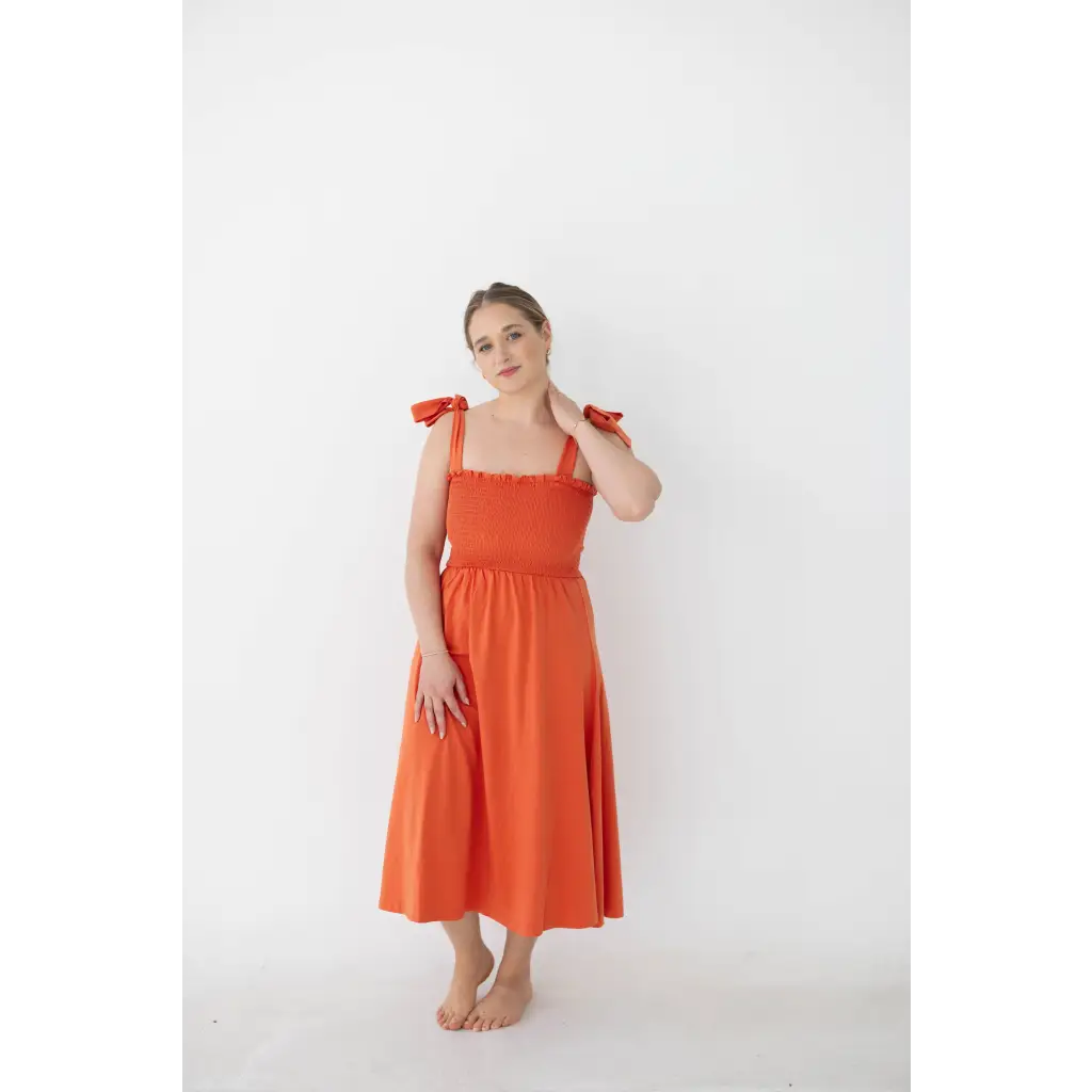 Bright orange day dress with tied straps and smocked bodice for a fun summer look