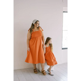 Matching orange day dresses with gathered waists and tied shoulder straps