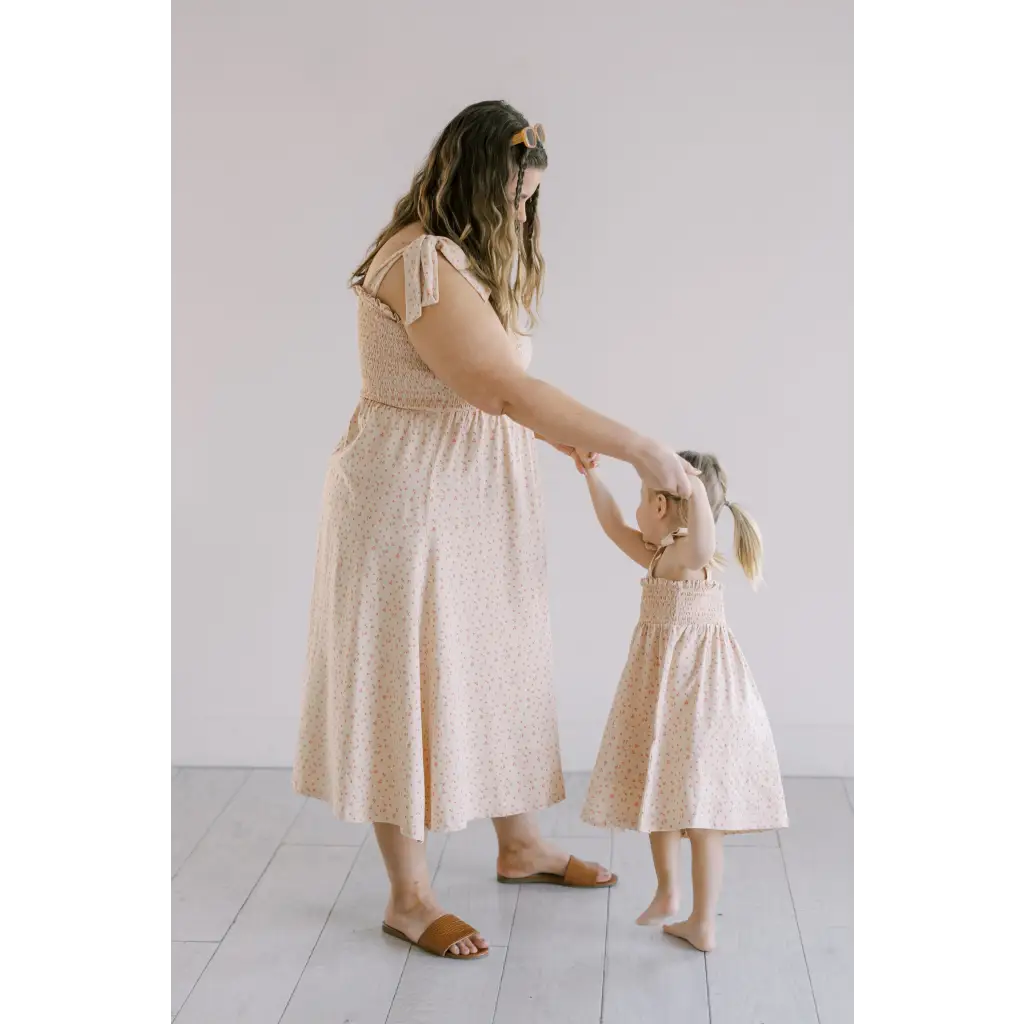Cream-colored day dress with flutter sleeves and smocked bodice, perfect for sunny days