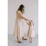 Cream-colored day dress with flutter sleeves and smocked bodice, perfect for sunny days