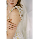 Bare shoulder with striped fabric straps of a stylish Striped Day Dress designed for summer