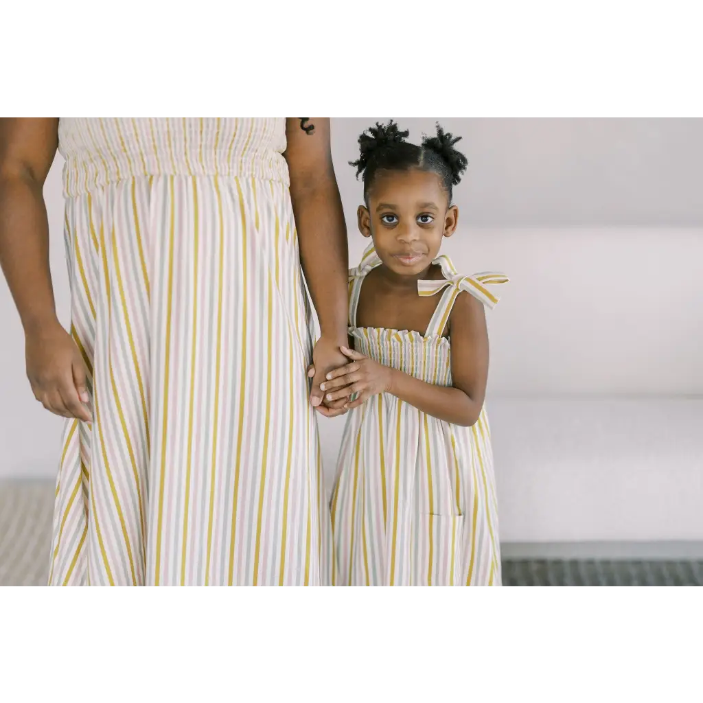 Matching yellow and white striped day dresses with shoulder ties for a chic summer look