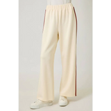Cream tracksuit pants with red side stripes and elastic waistband for a comfy look