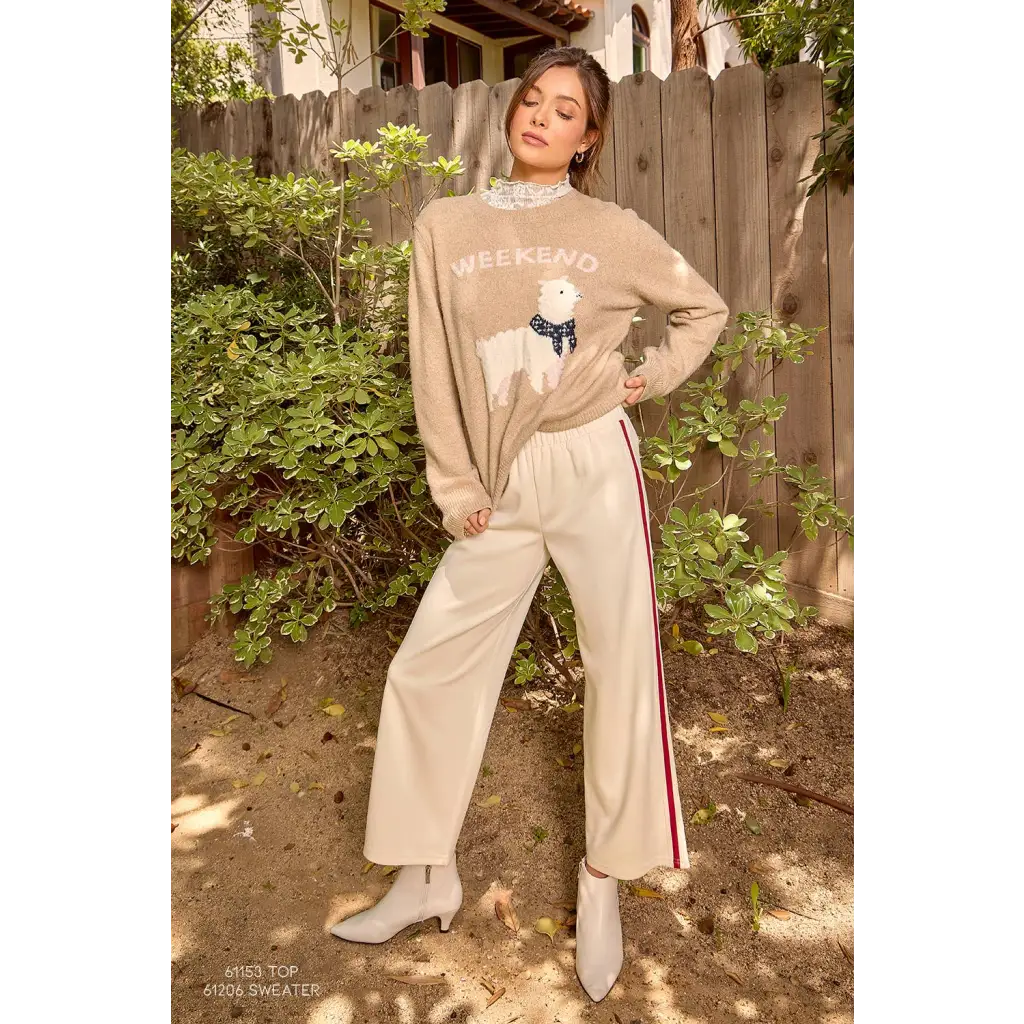 Beige weekend sweater with llama design, paired with cream tracksuit pants and white boots