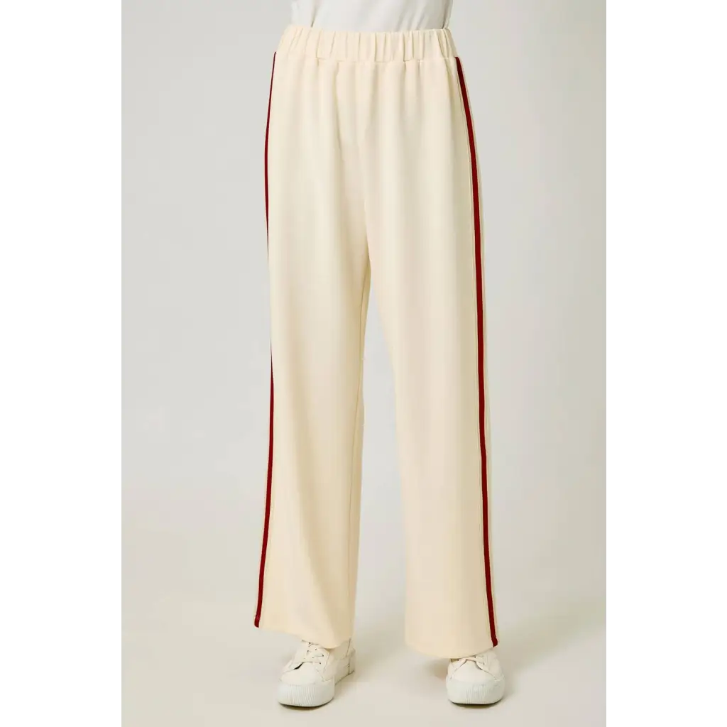 Cream tracksuit pants with red side stripes and elastic waistband for a casual look